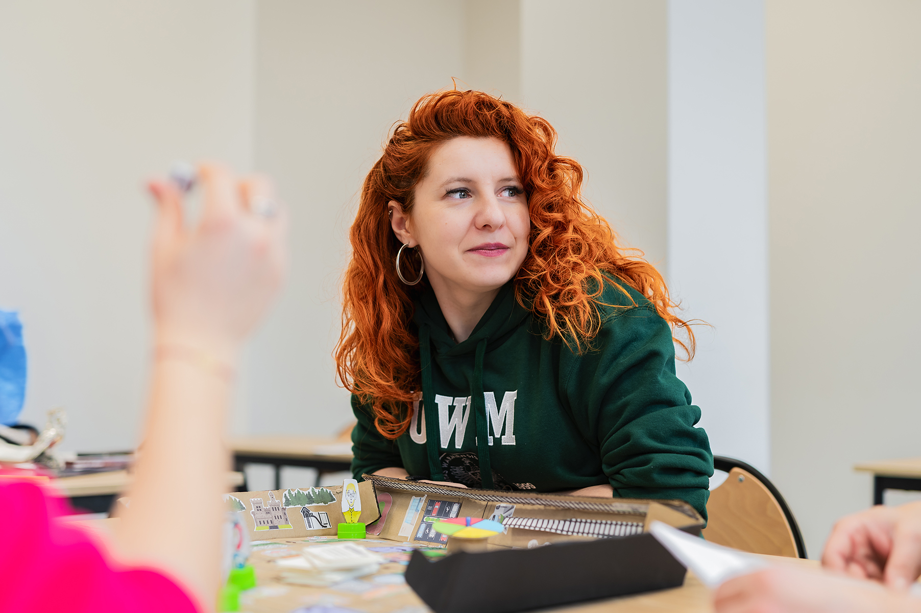 Kobieta siedzi przy stole i uczestniczy w zajęciach warsztatowych