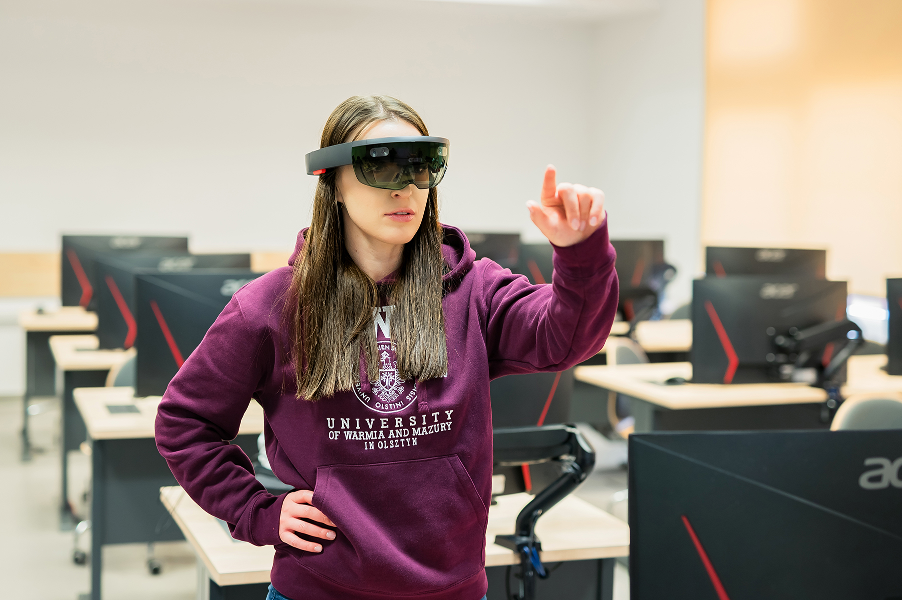 Studentka korzysta z okularów rozszerzonej rzeczywistości w pracowni komputerowej