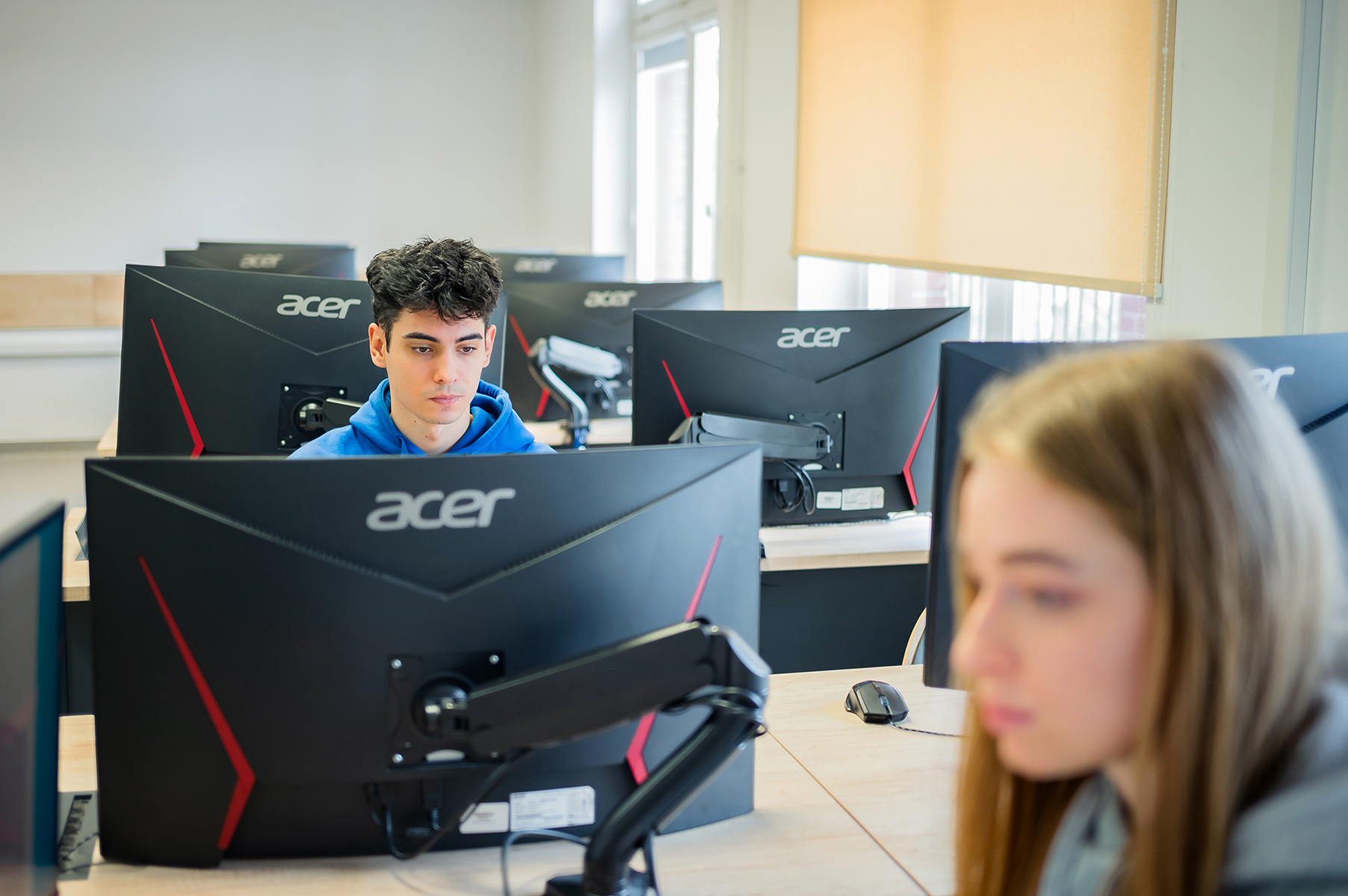 Studenci pracują przy komputerach w sali dydaktycznej