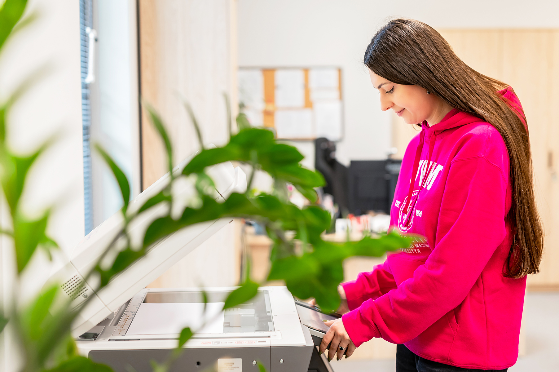 Kobieta obsługująca kserokopiarkę w biurze