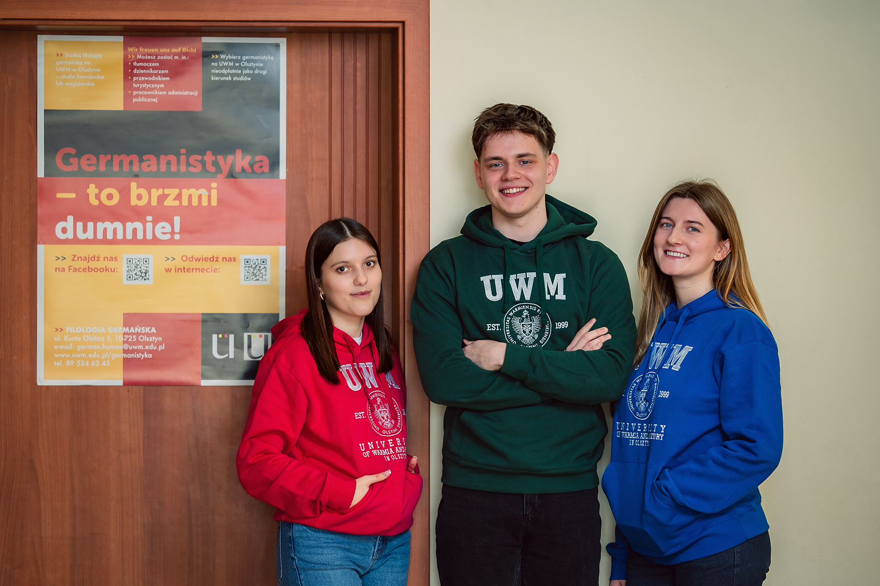 Troje studentów przy plakacie z hasłem „Germanistyka – to brzmi dumnie!”