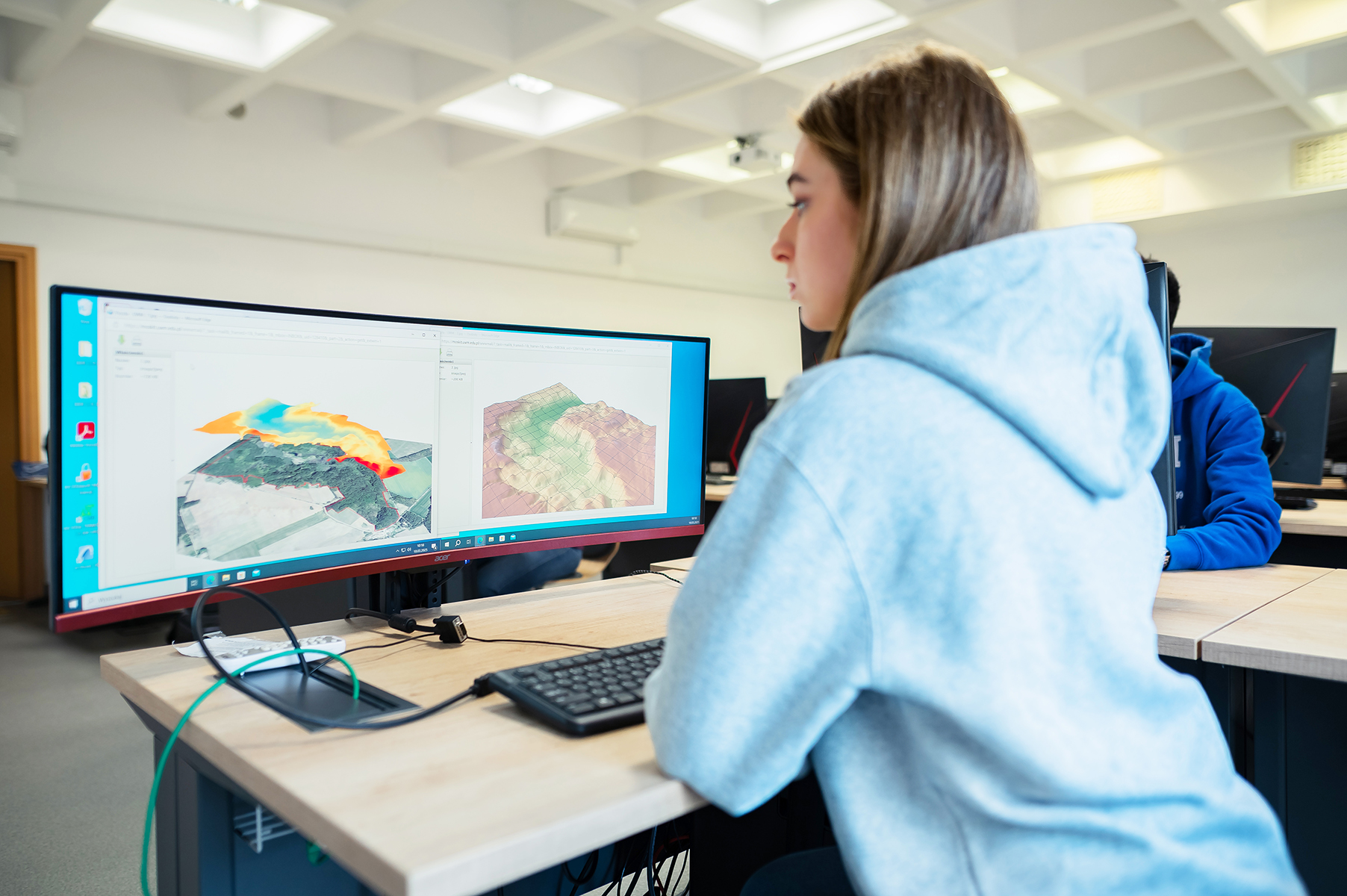 Studentka pracuje przy komputerze z wizualizacją danych przestrzennych
