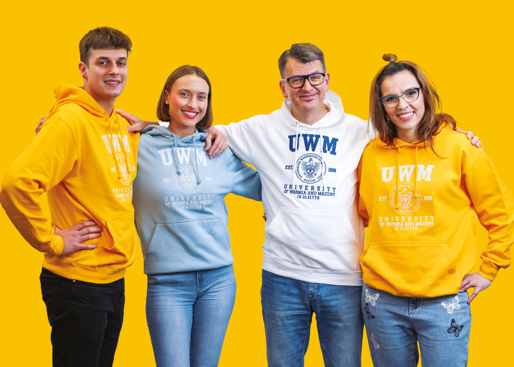 Uśmiechnięci studenci i ich wykładowcy w bluzach UWM